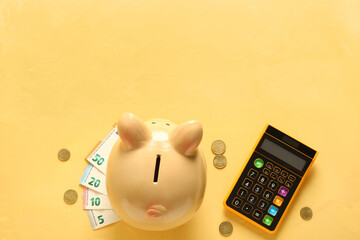 Naklejka premium Piggy bank with coins, euro banknotes and calculator on yellow background