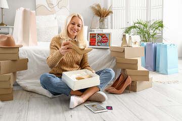 Mature woman with new shoes in bedroom. Online shopping