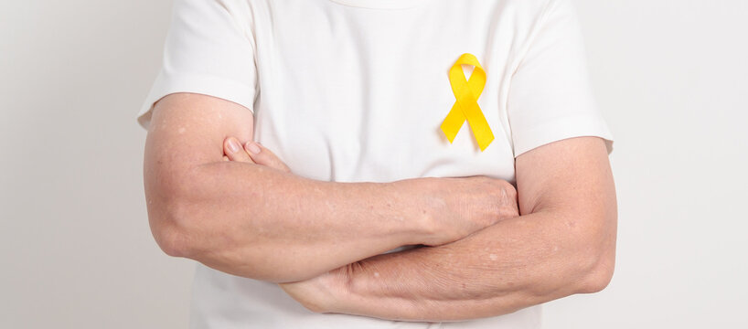 Elderly with Yellow Ribbon for concept of yellow September, Suicide prevention day, Childhood, Pediatric, May Missing Children Awareness day month, support survivor. Healthcare and World Cancer day