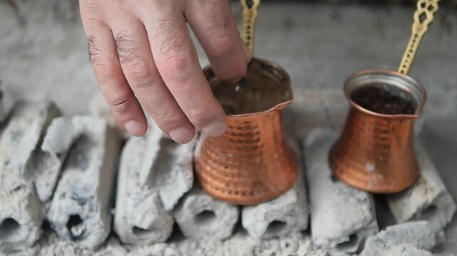 Making turkish coffee on hot coals in outdoor setting
