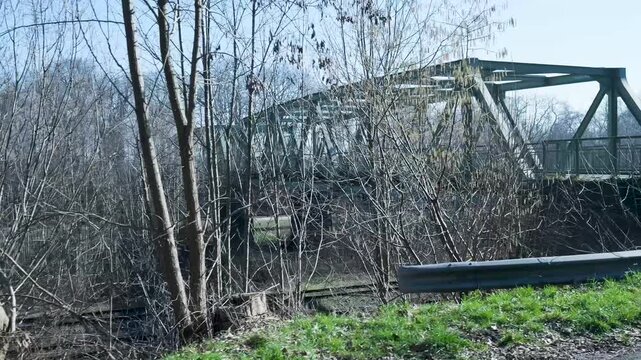 Point of view shot driving across a metal truss bridge