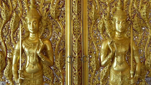 Close view ornate temple door golden thepphanom figure high relief layered carving sacred Thai ornament craftsmanship.