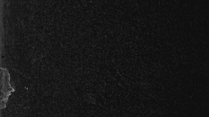 Fototapeta premium Dark textured desktop wallpaper with a rough, grainy surface and subtle light patches