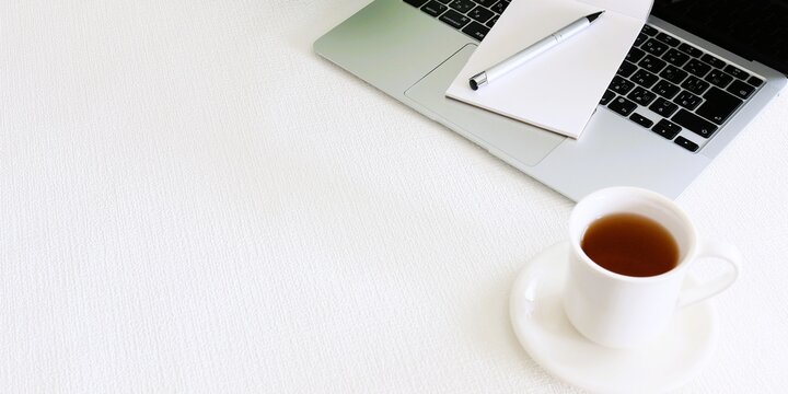 Minimal workspace with laptop and coffee, large copy space background