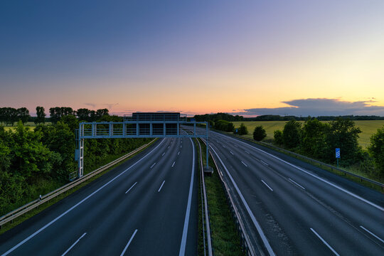 Empty German Autobahn Highway at Sunset with Gantry Sign and Scenic Horizon - real photography - authentic - no ai - True Long Exposure