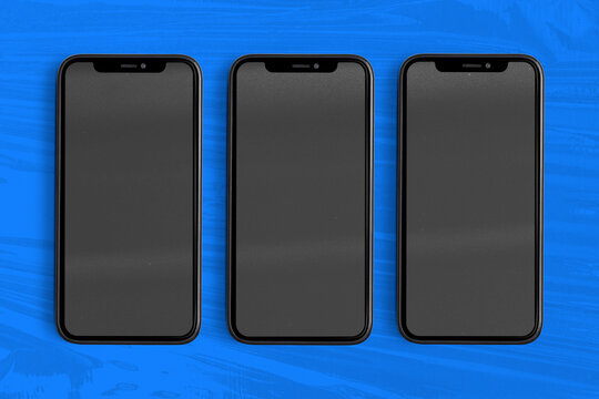 Three blank smartphones on blue background, suitable as mockup