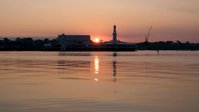 Silhouetted Cunningham Pier at sunset with golden reflections on the water, historic waterfront landmark in Geelong, Victoria, Australia. Peaceful regional city.