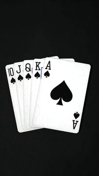 A hand of four spade playing cards on a black background