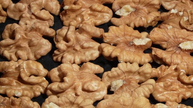 Rotating full frame macro texture of densely packed shelled walnut kernels. Premium organic raw food and healthy nutrition concept.