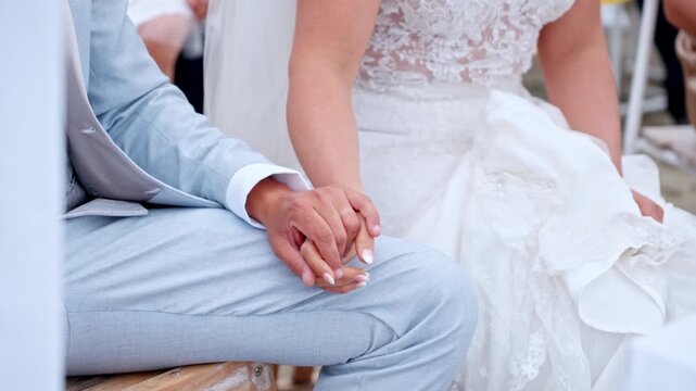 Bride and groom holding hands at wedding, romantic and loving moment