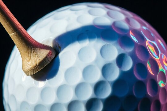 Surreal White Golf Ball Pierced by Wooden Tee with Neon Light