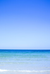 Fototapeta premium Crystal Clear Turquoise Water on White Sand Beach with Blue Sky at Chumphon, Thailand.