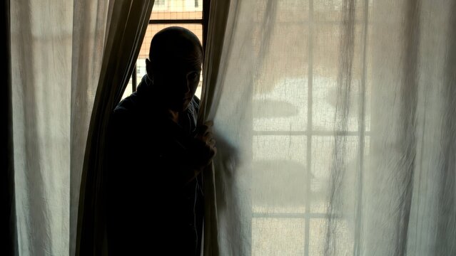 Silhouette of Person Behind Sheer Curtain in Soft Light Room