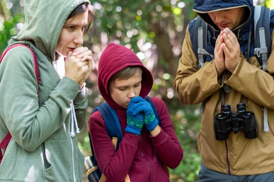 Family praying outdoors together photo