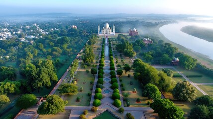 Fototapeta premium Aerial View of the Taj Mahal Surrounded by Lush Green Gardens and River at Dawn with Mist in the Air