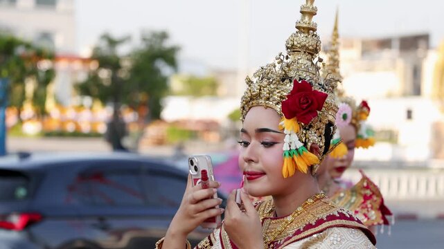 Thai Traditional Dancer Applying Red Lipstick Using Smartphone as Mirror