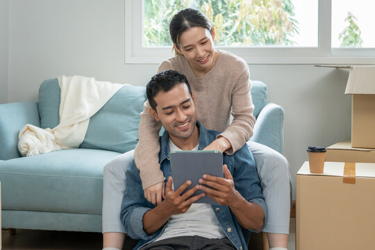 Moving house, relocation. Couple choose design for building new apartment, inside the room was a cardboard box contain personal belongings and furniture. move in the new apartment or condominium