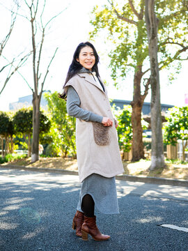 Full Body Portrait of a Stylish Japanese Woman in Trendy Winter Layered Fashion Standing Outdoors