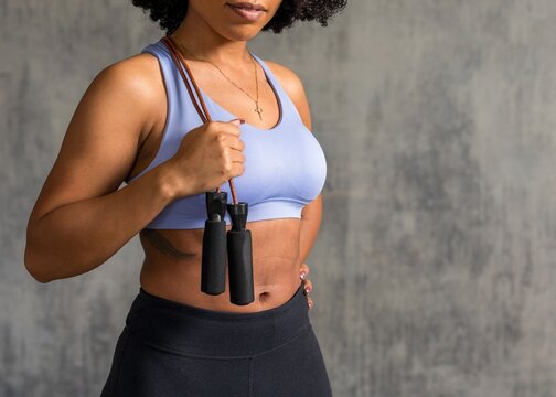 Woman holding jump rope confidently.