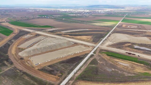 Drone view of a large highway interchange under construction near Pașcani, Romania, part of the future A7 and A8 motorway network. The scene shows earthworks, road layout, and infrastructure