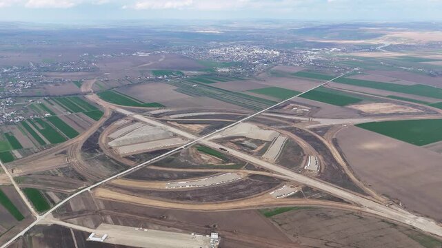 Cinematic drone orbiting near A7 and A8 highway intersection near city of Pascani in Romania