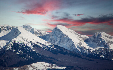 Naklejka premium a spectacular sunset over the snow-capped mountains