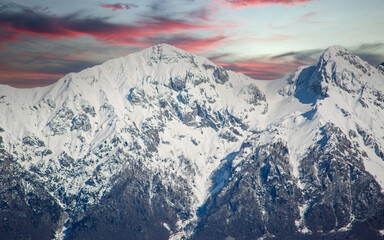 Fototapeta premium a beautiful red sunset over the snow-capped mountains