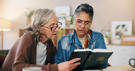 Fototapeta premium Reading, bible and mature women in house with learning religion, praise or worship together. Holy book, bonding and female friends with studying for spiritual wellness in living room at apartment.