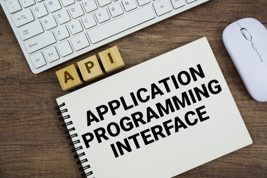 API Application Programming Interface message with keyboard and optical mouse on wooden background