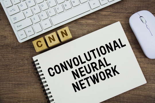 CNN Convolutional Neural Network message with keyboard and optical mouse on wooden background