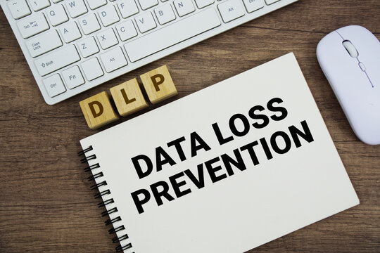 DLP Data Loss Prevention message with keyboard and optical mouse on wooden background