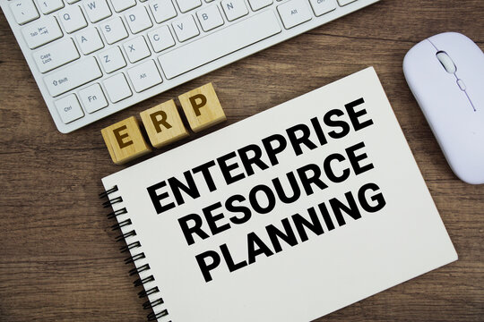 ERP Enterprise Resource Planning message with keyboard and optical mouse on wooden background