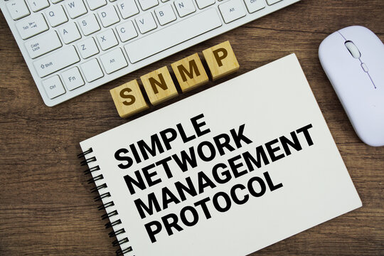 SNMP Simple Network Management Protocol message with keyboard and optical mouse on wooden background