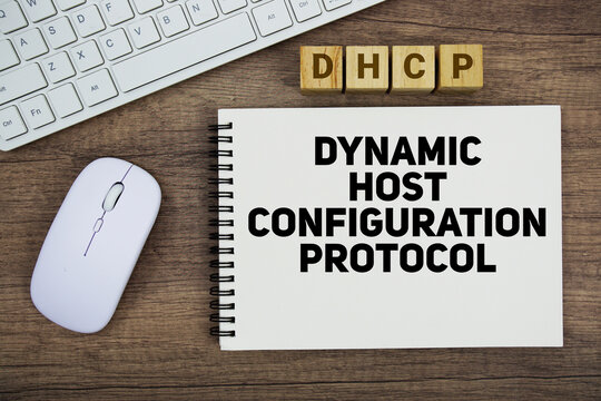 DHCP Dynamic Host Configuration Protocol message with keyboard and optical mouse on wooden background