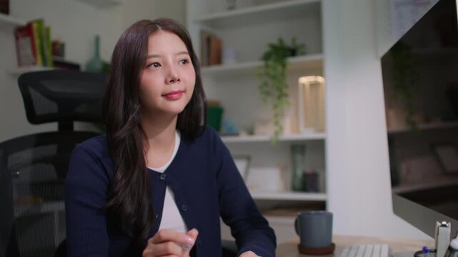 Modern Asian woman sitting in a cozy room, thoughtfully journaling in her notebook as part of her mindful morning routine, embracing slow living, self-reflection, intentional productivity