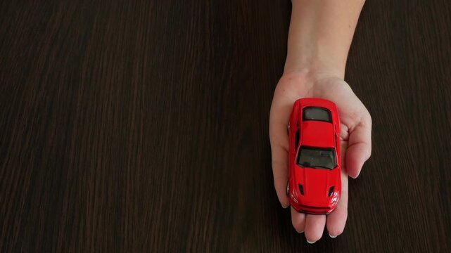 Zefir or marshmallows as pink rose and red car model in hand, Gift concept.