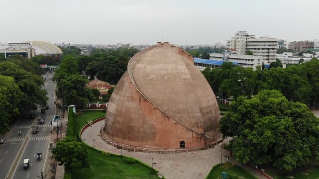 Aerial drone view of Golghar in Patna, Bihar, showcasing the iconic historic granary surrounded by urban landscape, greenery, and the scenic skyline of the city.

