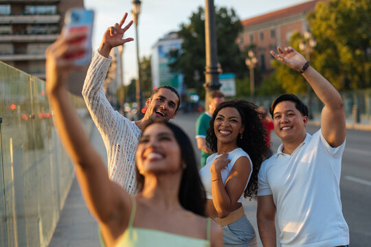 Diverse friends taking selfie together on city street