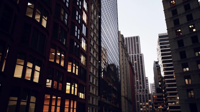 evening city street between skyscrapers with warm lit windows and brick facades, narrow canyon perspective, mirrored glass reflecting soft sunset, moody