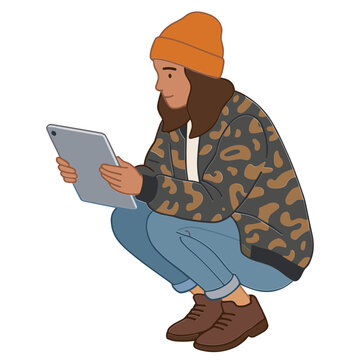 A man in casual clothes is crouching while using a tablet.