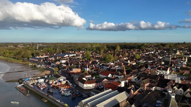 Reverse aerial view of Manningtree, Essex on the River Stour under partly cloudy sky