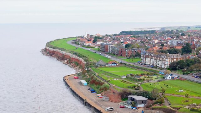 Aerial video of the British seaside town of Hunstanton in Norfolk showing the coastal area and beach and alsop the caravan holiday park. Chalk white cliffs with a lighthouse and sandy beach