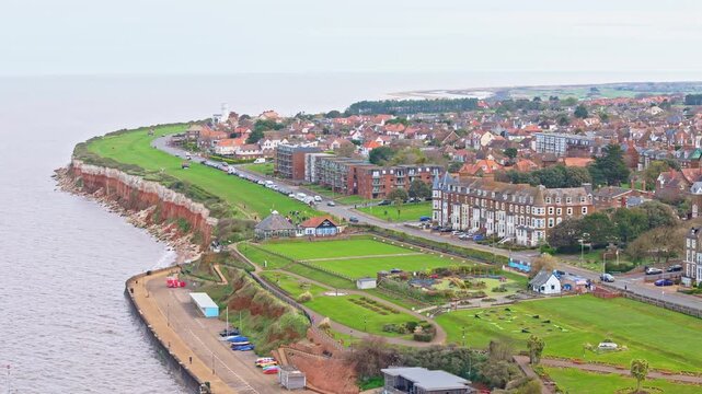 Aerial video of the British seaside town of Hunstanton in Norfolk showing the coastal area and beach and alsop the caravan holiday park. Chalk white cliffs with a lighthouse and sandy beach