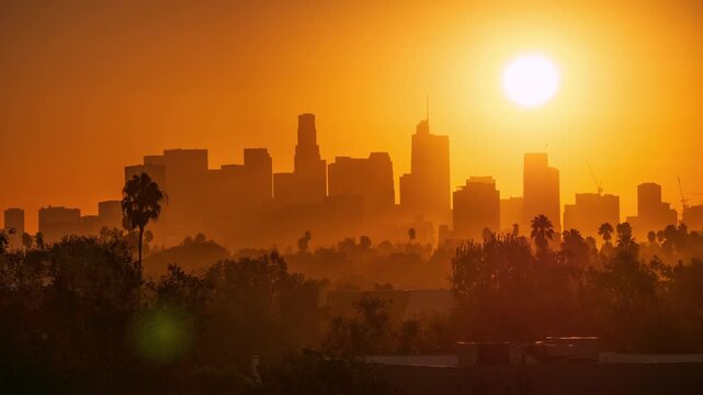 Sunrise over city of Los Angeles skyline. Sun behind downtown LA skyscrapers.