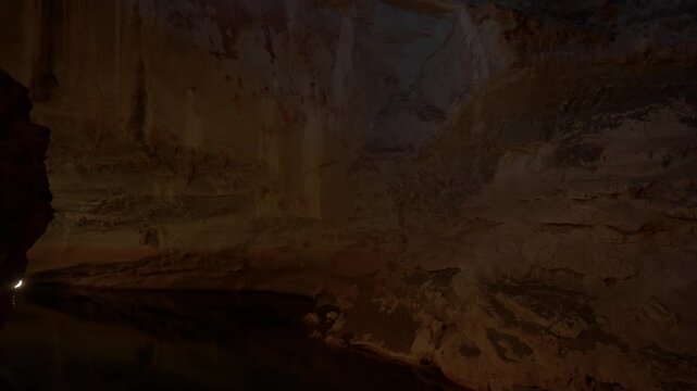 Tilt up and pan with wide angle lens in the shadows of Tham Nang Ene's chambers, with amazing rock colours showing through.