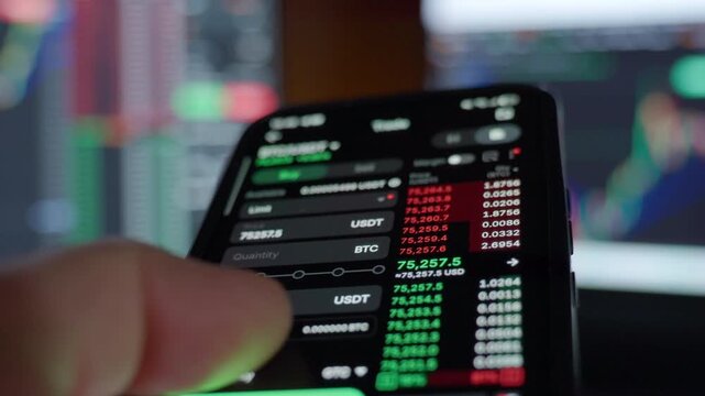 Investor trading stocks on mobile app with financial market screens. Hand holding smartphone with stock market chart. Concept of financial growth, online investing and market volatility