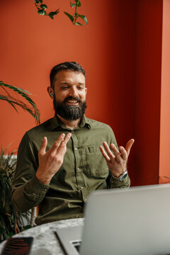 Bearded man having video call meeting gesturing