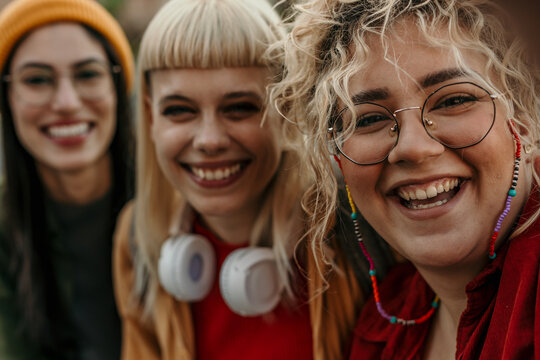 Three happy diverse women friends laughing together