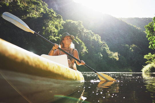 Smile, kayak and explore with woman in lake for forest adventure, journey or eco tourism. Wildlife expedition, canoe boat and weekend break with person rowing in nature for summer vacation and travel