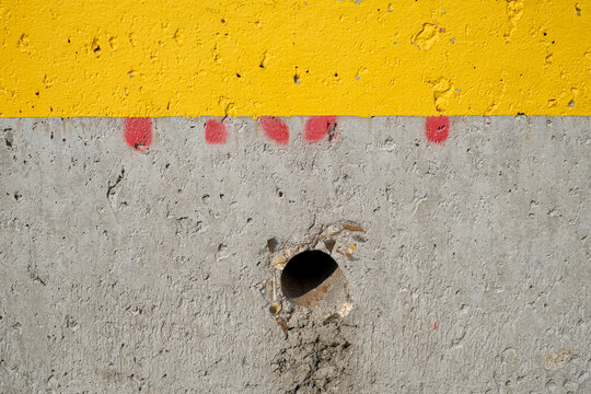 mur en b&eacute;ton peint d'une bande en jaune